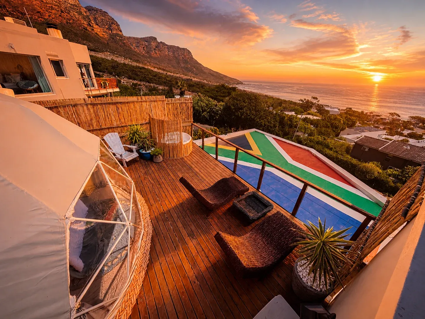 Glamping dome on a wooden deck overlooking the sea at sunset